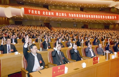 第二次全体会议上，代表们举手通过大会选举办法以及总监票人和副总监票人名单。记者 郑承锋 摄  