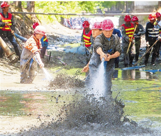 4月29日，杭州西湖区二号浦整治工程现场，工人们正用高压水枪冲洗河床淤泥。