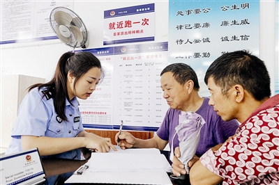 梓桐镇便民服务中心公安窗口，唐国放（中）顺利取到了新办的身份证。