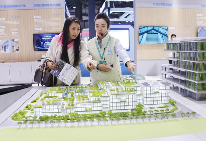 11月6日,讲解员(右)在住博会上向观众介绍展出的节能建筑。新华社记者 潘旭 摄