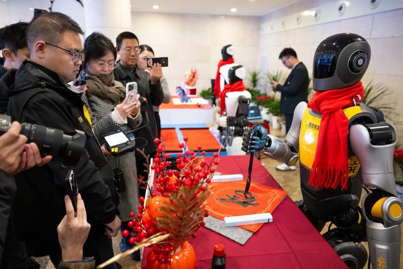 2026年2月24日,人形机器人在湖北省加快建成中部地区崛起的重要战略支点推进大会上亮相,现场进行书法表演。新华社记者 肖艺九 摄